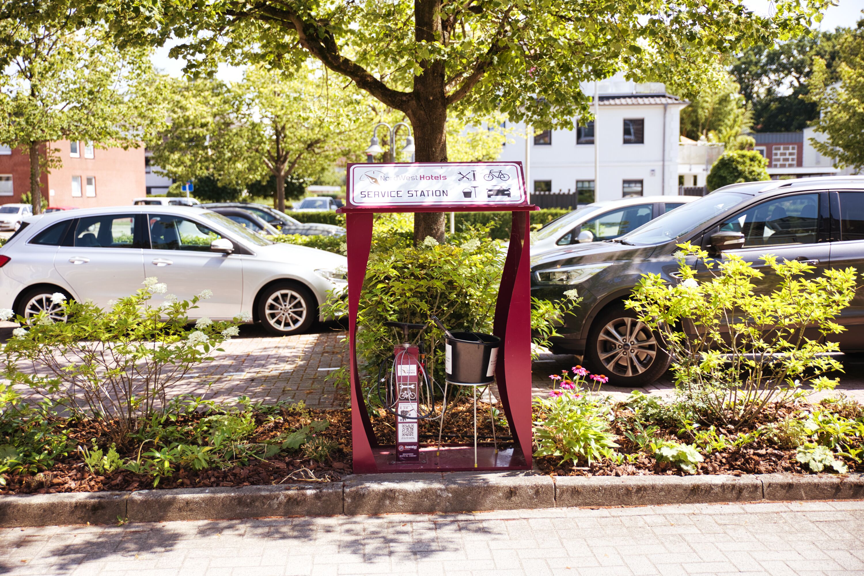 A parking area with a sign indicating service station facilities, including a fuel pump and a bicycle rack.