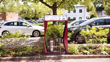 A parking area with a sign indicating service station facilities, including a fuel pump and a bicycle rack.
