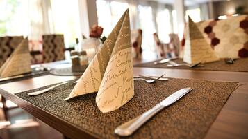 A table set with a placemat, a knife, and a folded napkin with cursive writing.