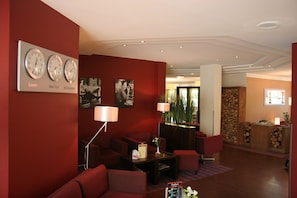 Sala de estar moderna com paredes vermelhas, lareira e relógio mostrando Londres, Nova York e Bad Zwickau.