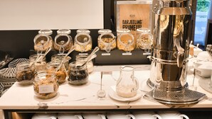 Un área de buffet con distintos alimentos en frascos y una máquina de café.
