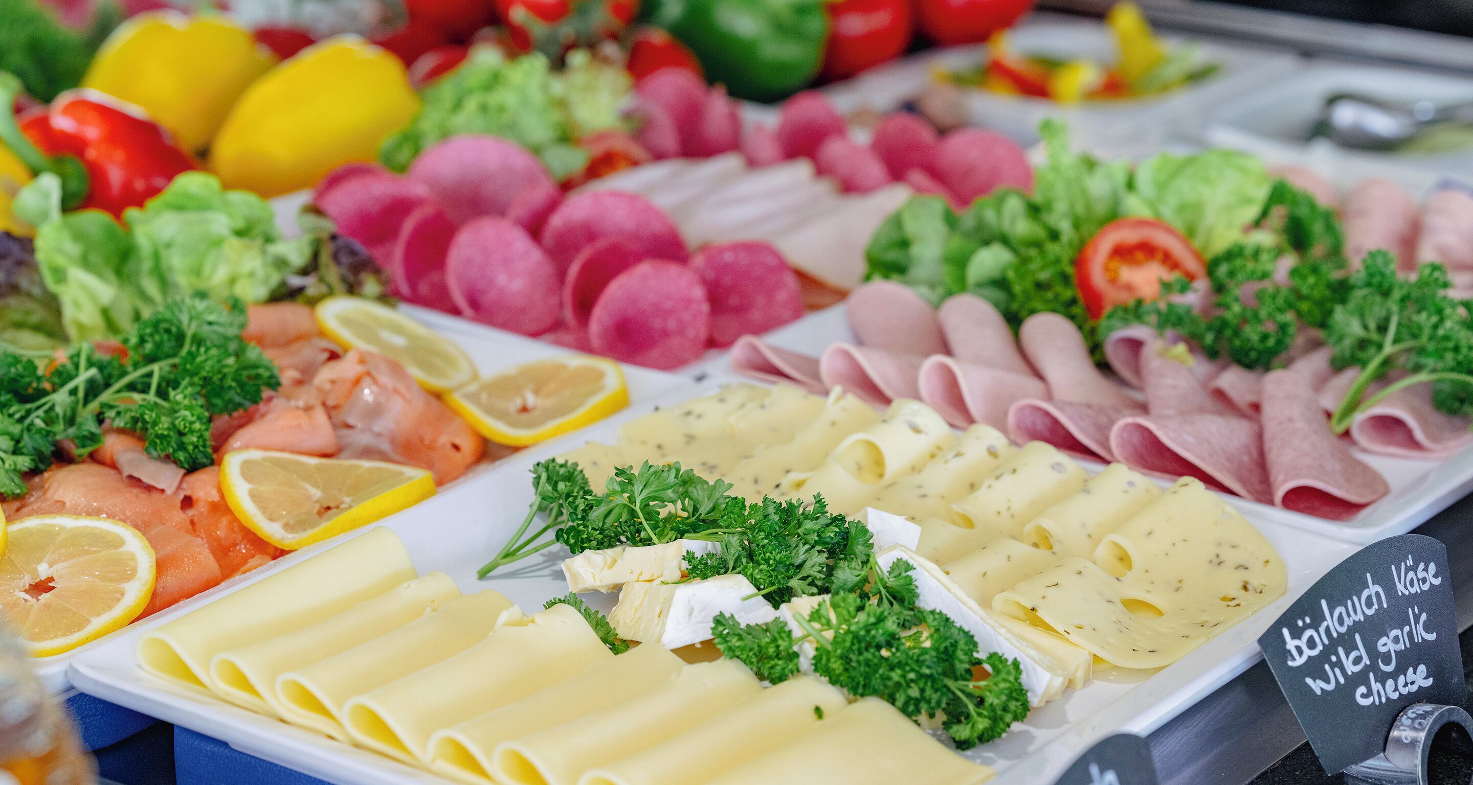A variety of cheeses and meats on a display table.