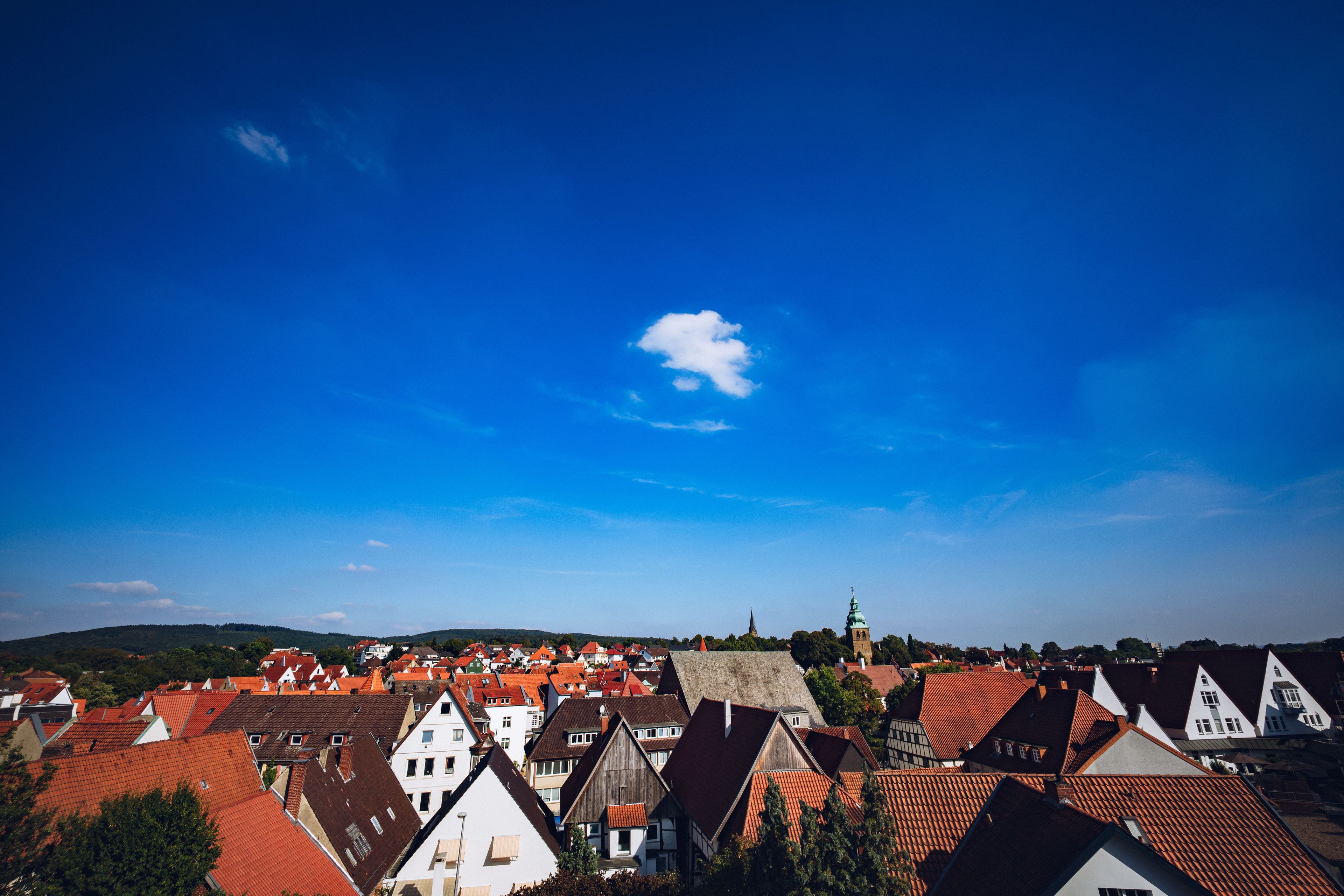 A town with red-roofed buildings and a church with a green spire.