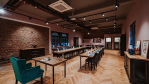 A spacious conference room with a long table, multiple chairs, and a brick wall. - Der LIPPISCHE HOF (Bad Salzuflen)
