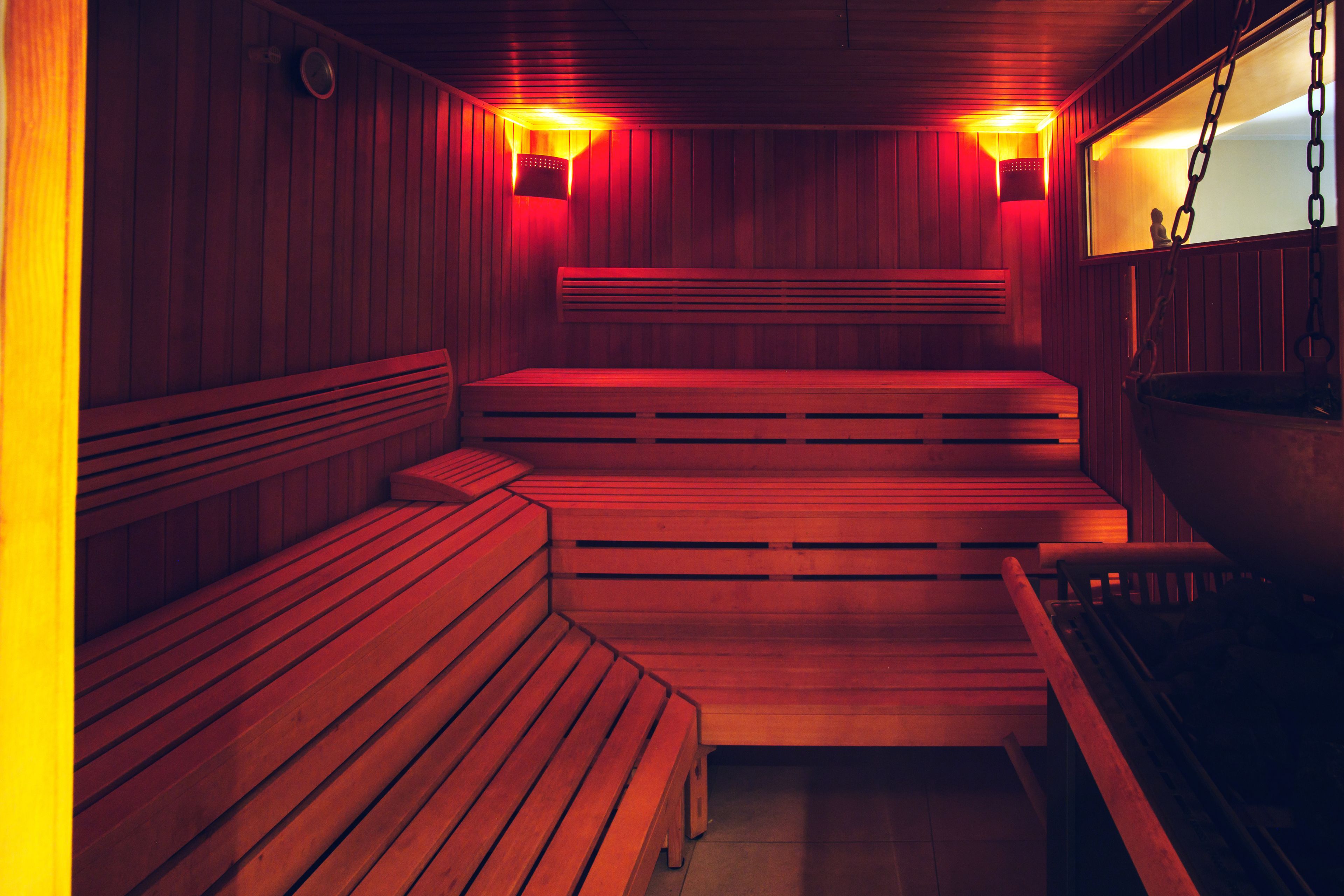 Una sauna con bancos de madera y dos luces fijadas en la pared.