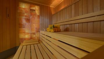 A sauna with wooden benches and a stone wall.
