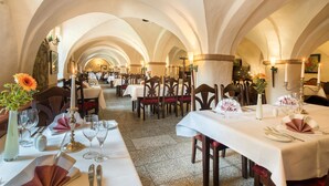 A dining area with tables set for a meal, featuring white tablecloths, candles, and floral centerpieces. - Wasserschloss Klaffenbach Schlosshotel (Chemnitz)