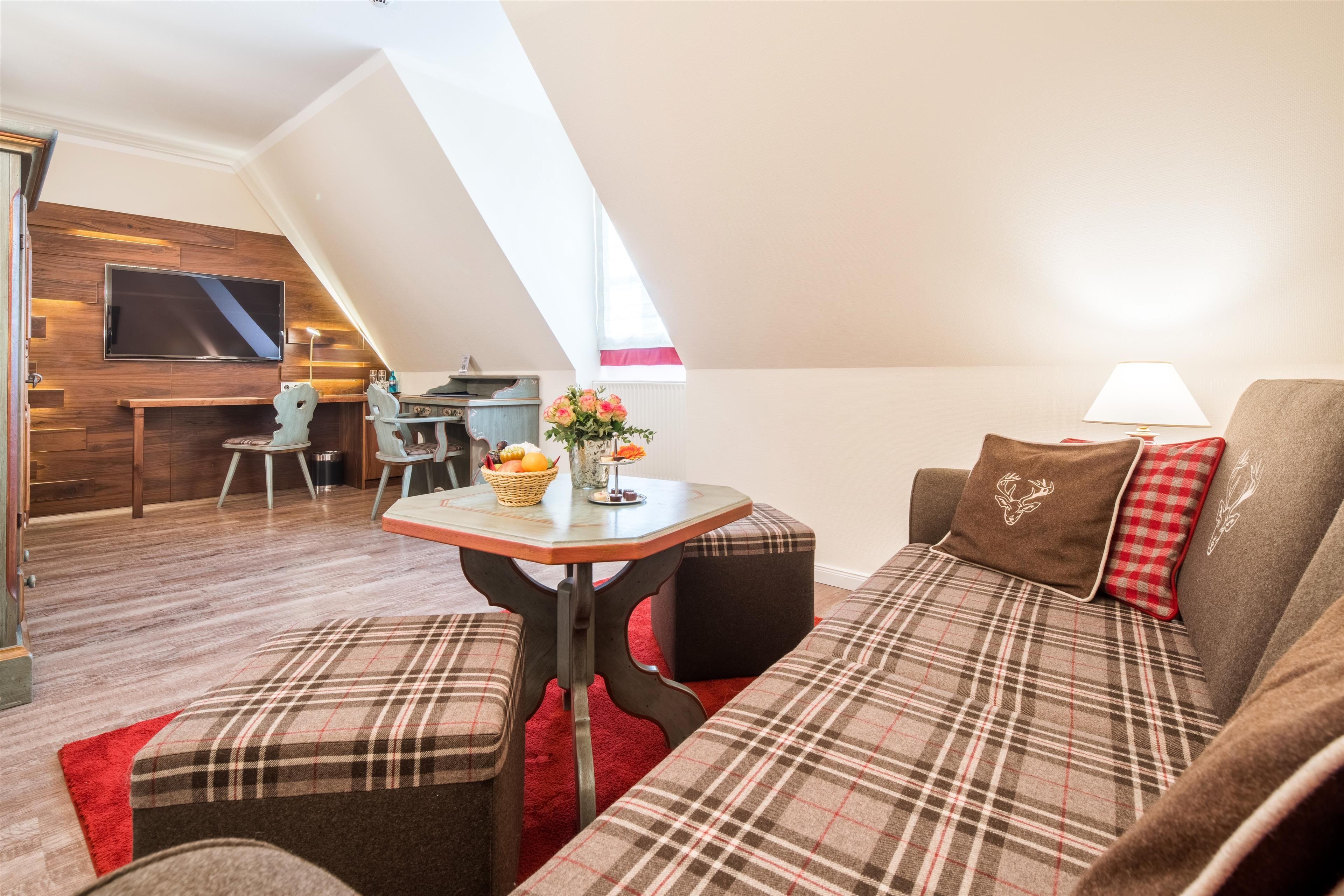 Un espace de vie chaleureux de style loft, doté d’un plafond haut, d’un coin repas et d’un téléviseur fixé au mur.