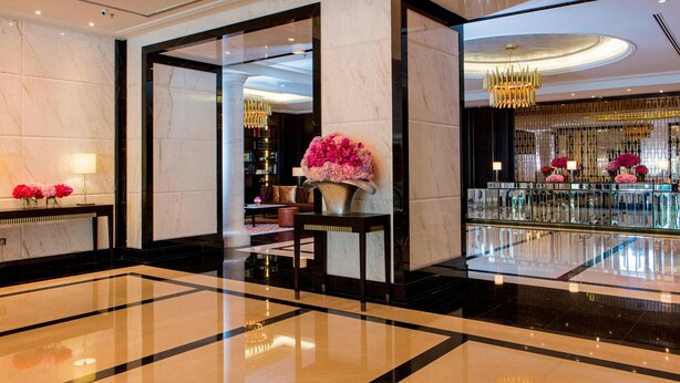 A spacious lobby with marble flooring, a reception desk, and a large floral arrangement. - The Ritz-Carlton, Kuala Lumpur (Kuala Lumpur)