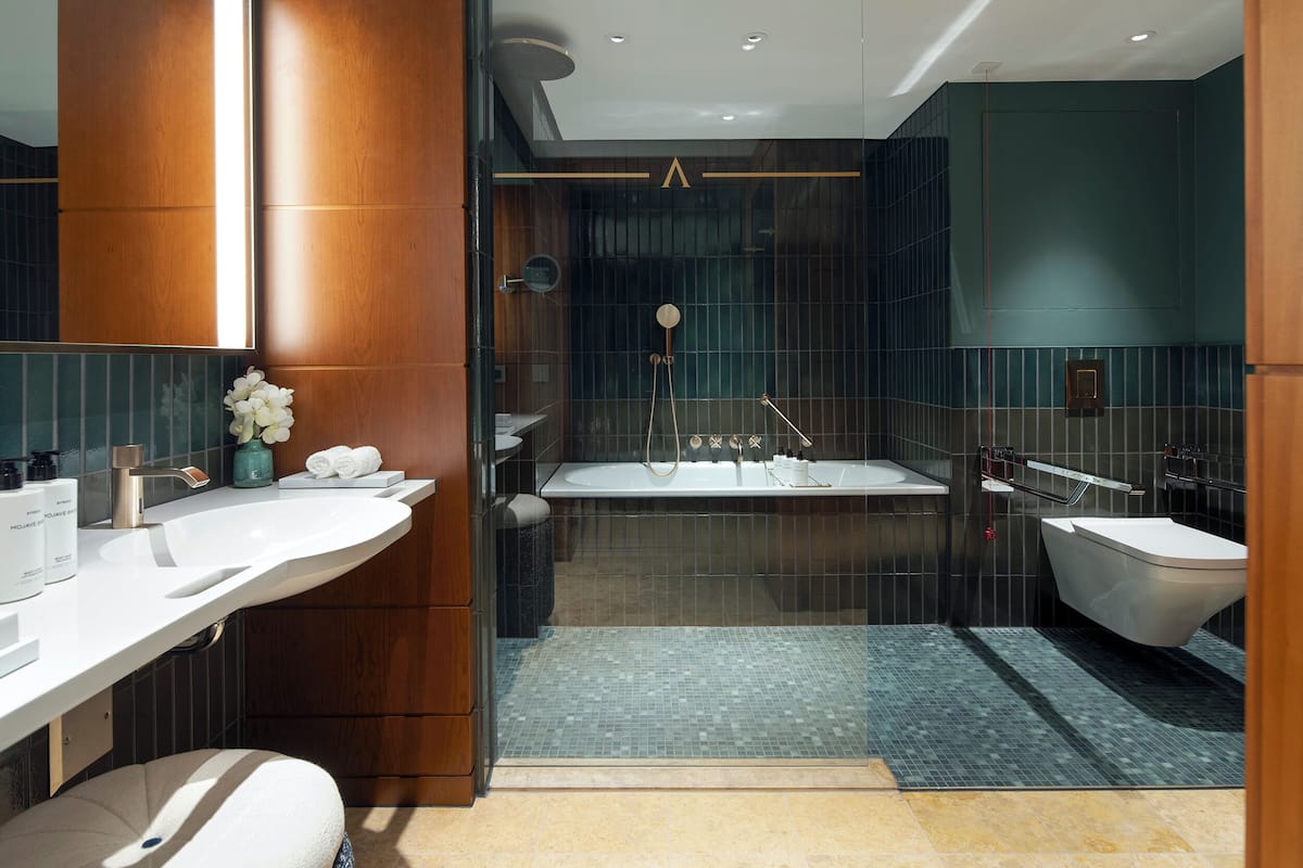 A modern bathroom with a large bathtub, a separate shower area, and a vanity with a mirror.