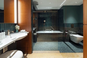 A modern bathroom with a large bathtub, a separate shower area, and a vanity with a mirror. - Conrad Hamburg (Hamburg)
