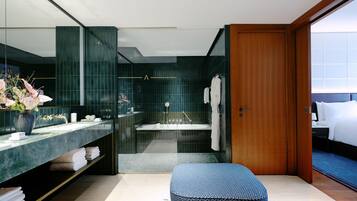Un baño moderno con un espejo grande, una bañera y una zona de ducha.