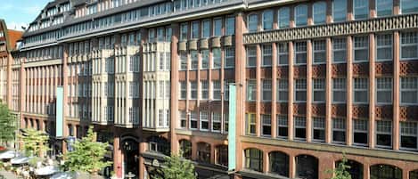 A multi-story building with a prominent 'BIA' sign, featuring a mix of brick and glass facades, large windows, and a central courtyard with outdoor seating.