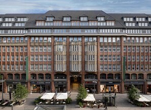 A multi-story building with a brick facade, large windows, and a central entrance. - Conrad Hamburg (Hamburg)