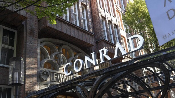 A building with a prominent 'CONRAD' sign, featuring a wrought iron archway and a brick facade. - Conrad Hamburg (Hamburg)