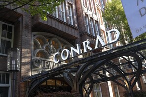 A building with a prominent 'CONRAD' sign, featuring a wrought iron archway and a brick facade. - Conrad Hamburg (Hamburg)