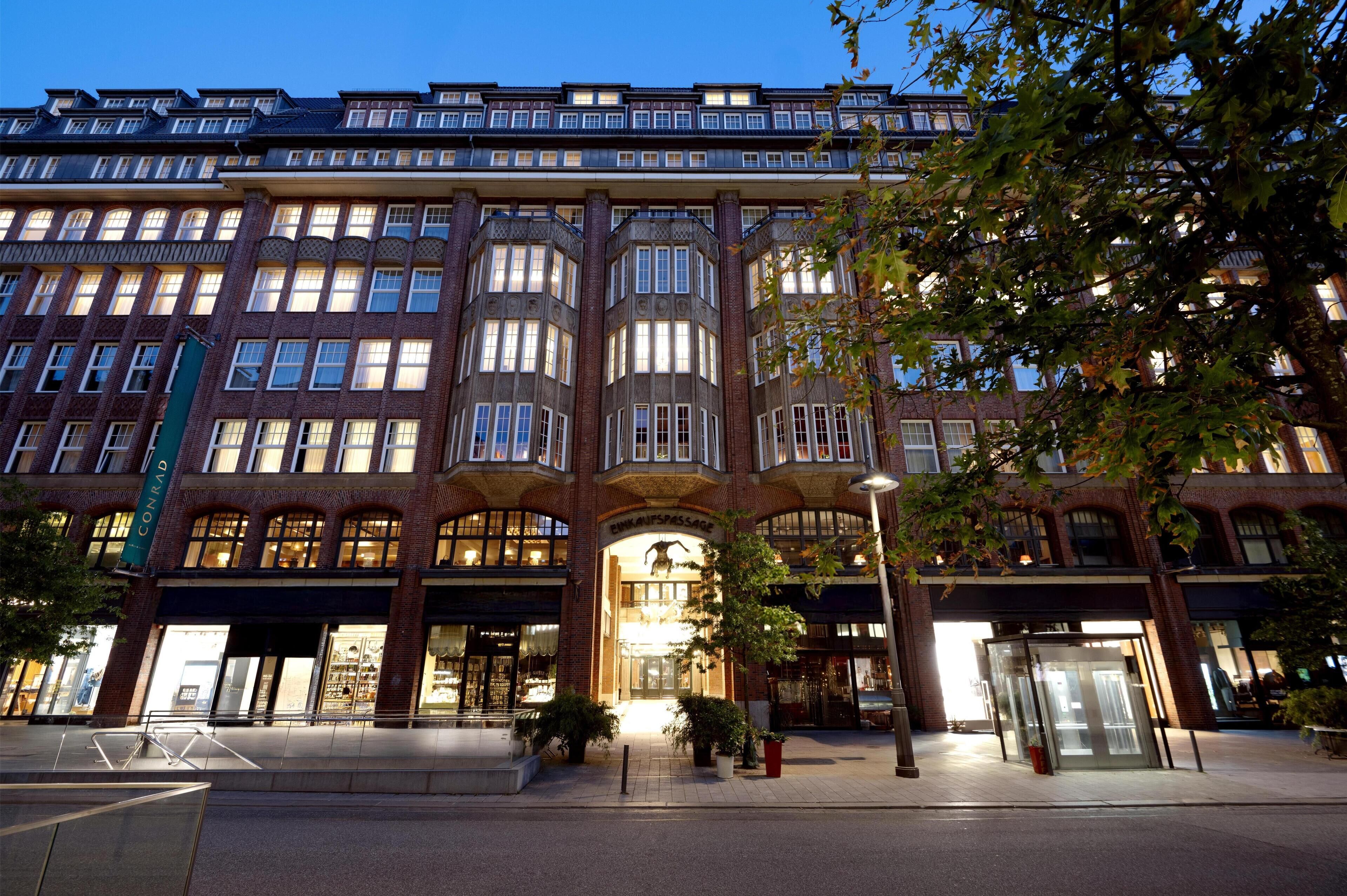 Un hotel de varios pisos con una entrada destacada, ventanas amplias y fachada de ladrillo.