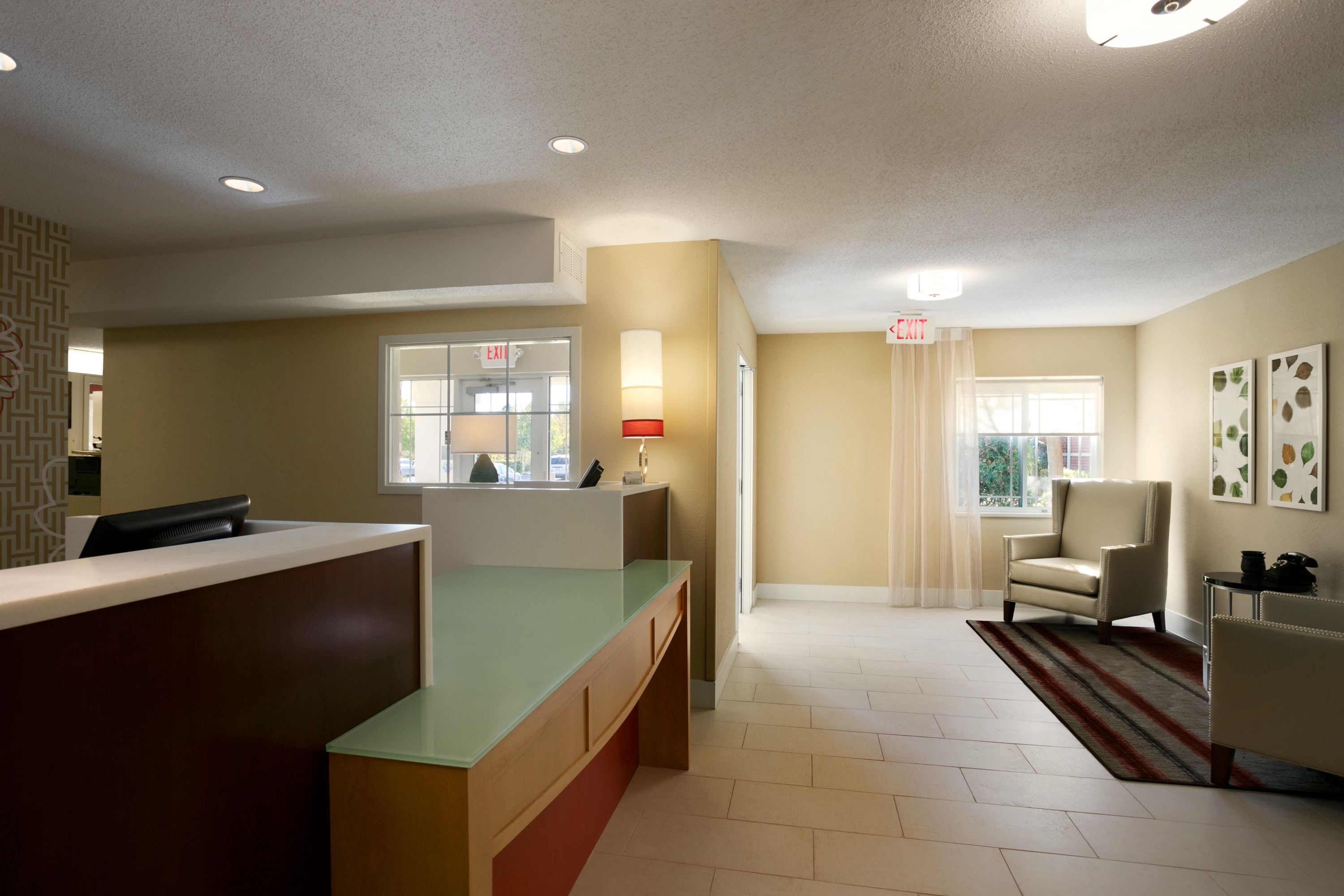 A reception area with a counter, a chair, and a lamp.