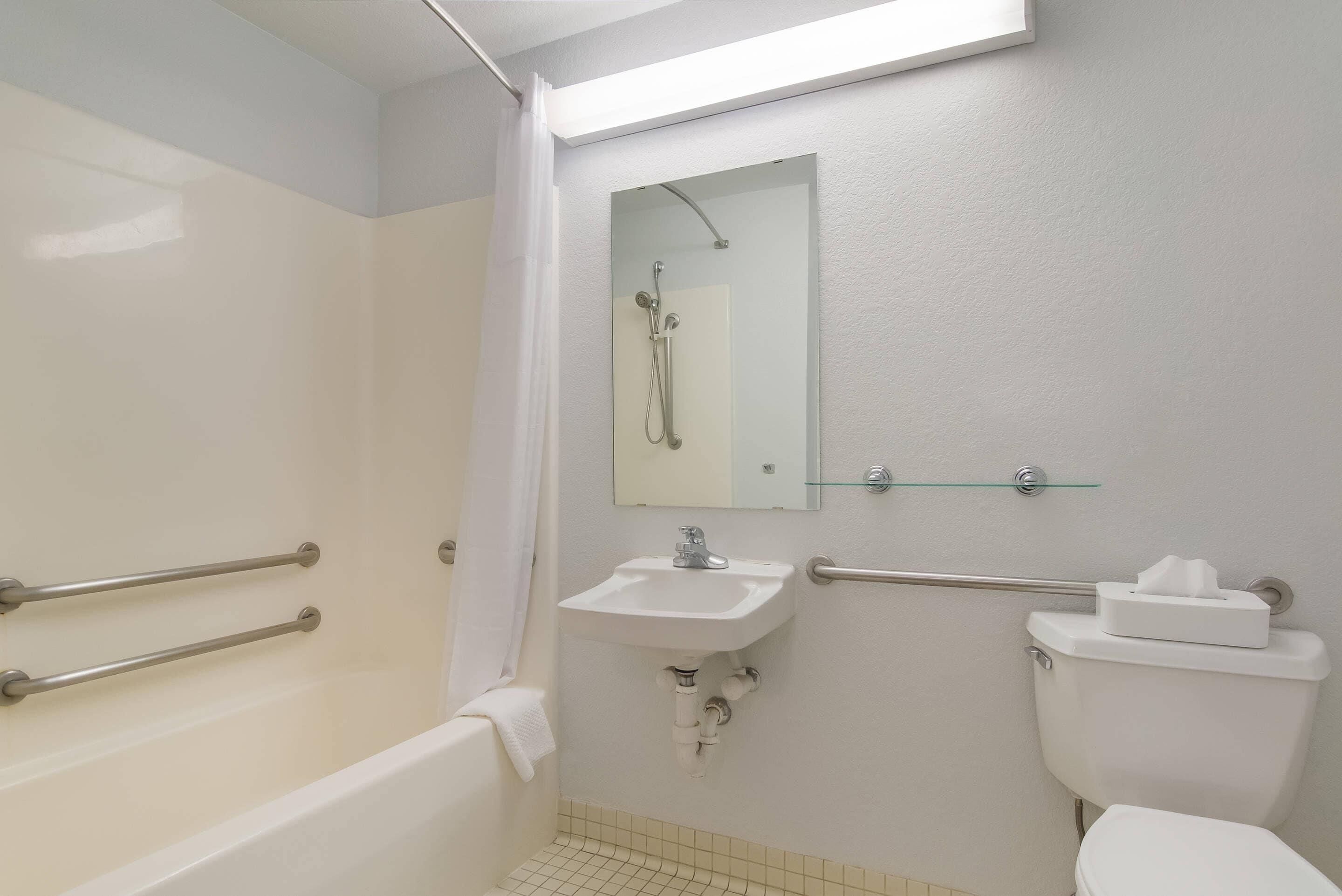 A bathroom with a bathtub, a sink, a toilet, and a glass shower enclosure.