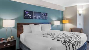 Una habitación de hotel con una cama grande, dos lámparas de noche, una mesita de noche y una silla.
