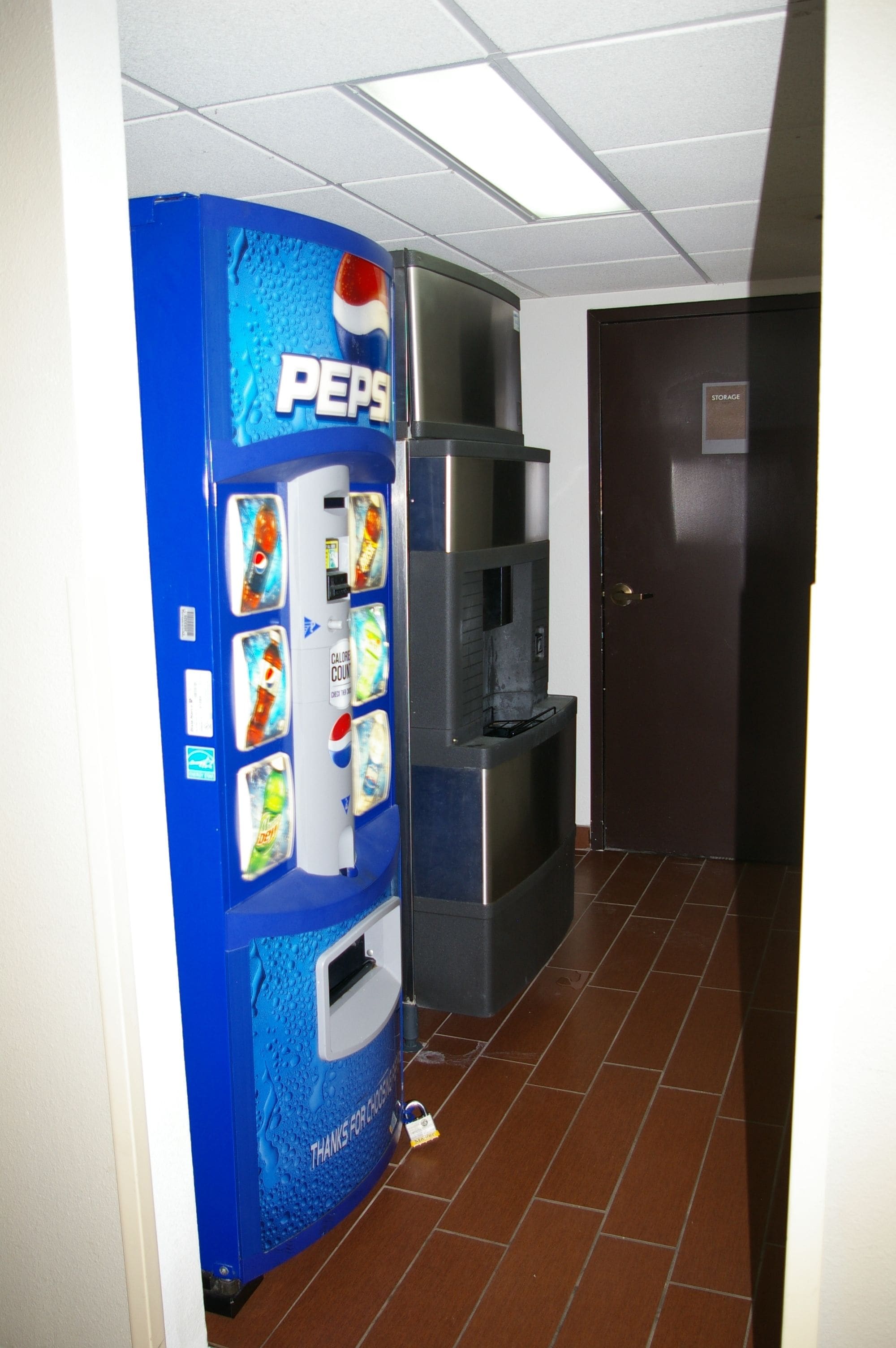 Ein Getränkeautomat mit Pepsi-Logo, ein Wasserspender und ein Mülleimer.