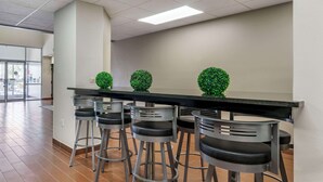 A bar area with four stools and a black bar counter, featuring three green spherical decorations.
