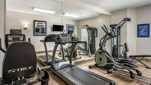 A gym with various exercise equipment including treadmills, ellipticals, and weight machines.