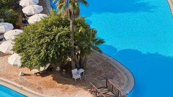 Een binnenzwembad, een buitenzwembad, parasols voor strand/zwembad