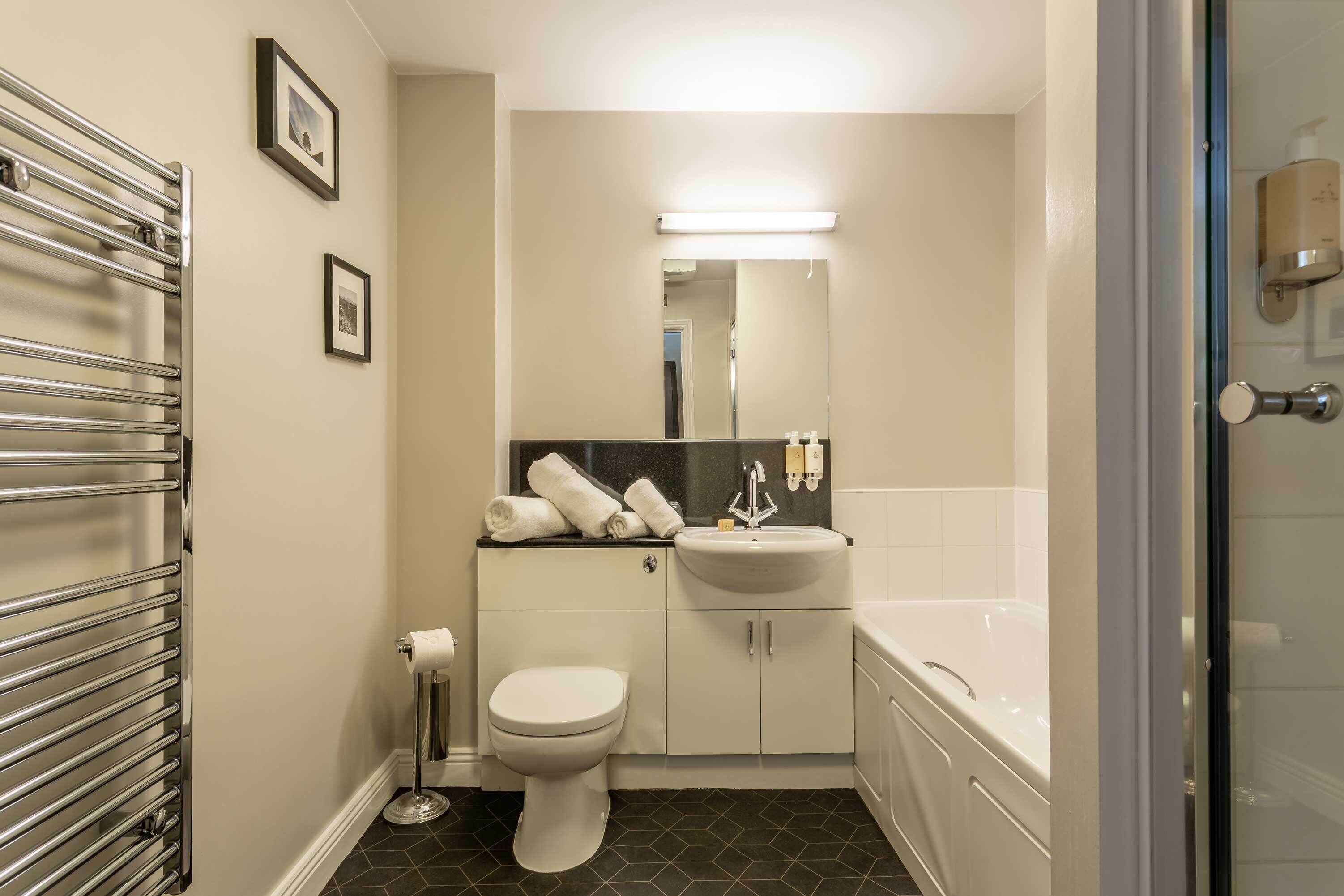 A bathroom with a toilet, sink, and bathtub.