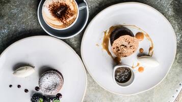 A dessert plate with a chocolate cake, caramel sauce, and berries.