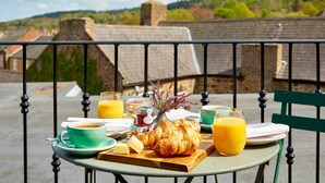 Desayuno en un balcón con croissants, zumo de naranja y café.