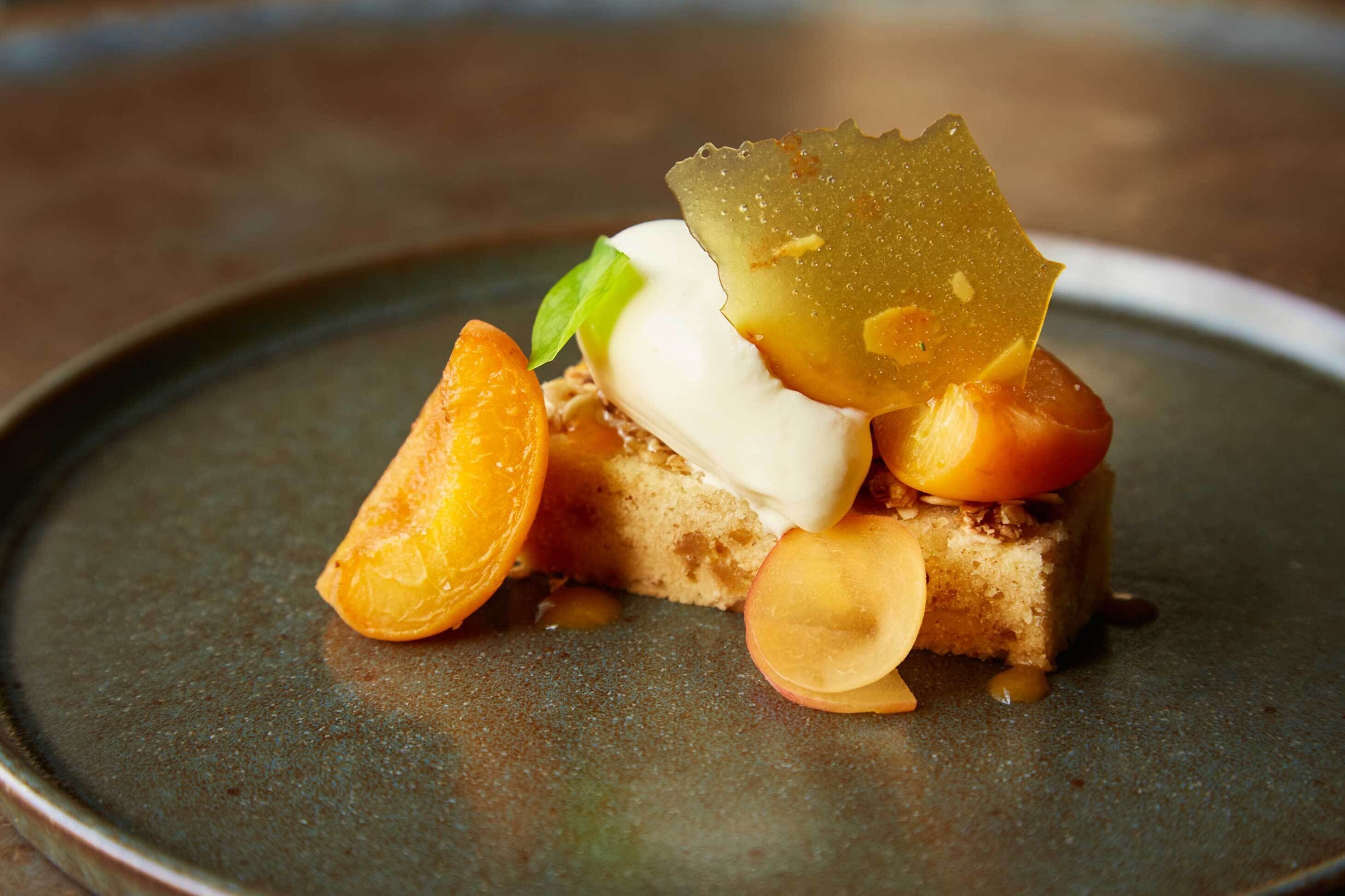 Sobremesa com fruta e um pedaço de bolo num prato.