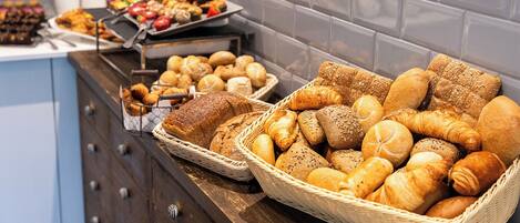 A buffet with various breads and pastries.