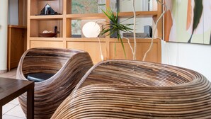 A modern interior with wicker furniture, a wooden cabinet with shelves, and a map on the wall. - ibis Leipzig Nord Ost (Taucha)