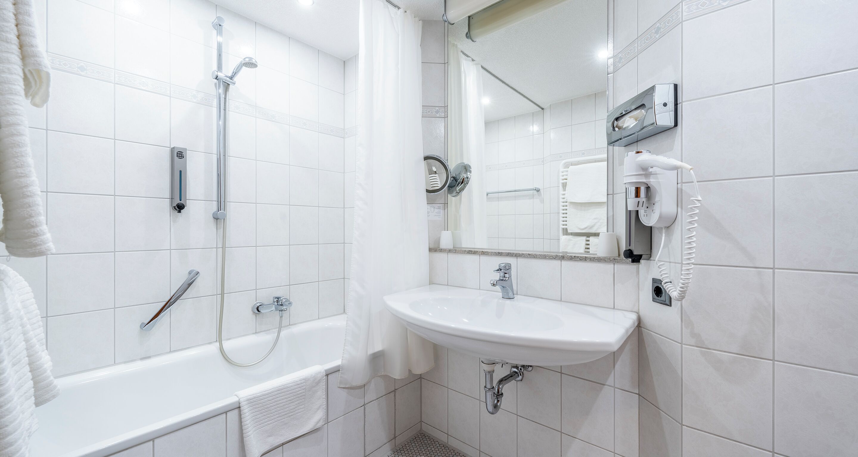 Ein modernes Badezimmer mit Badewanne, Dusche und Waschbecken.