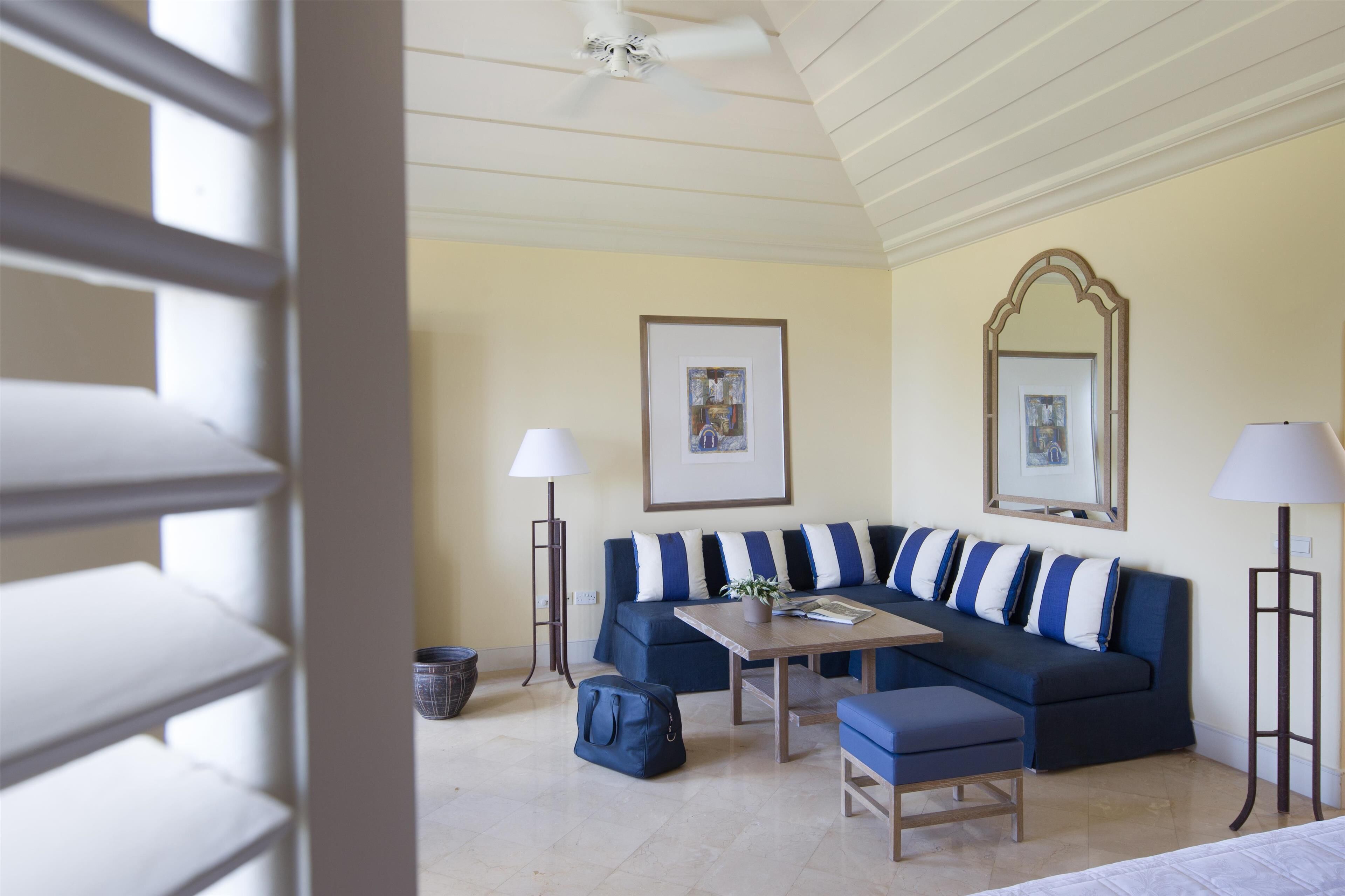 A living room with a blue sectional sofa, a wooden coffee table, and two floor lamps.
