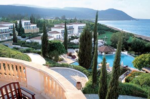 A coastal resort with multiple villas, a swimming pool, and a view of the sea.