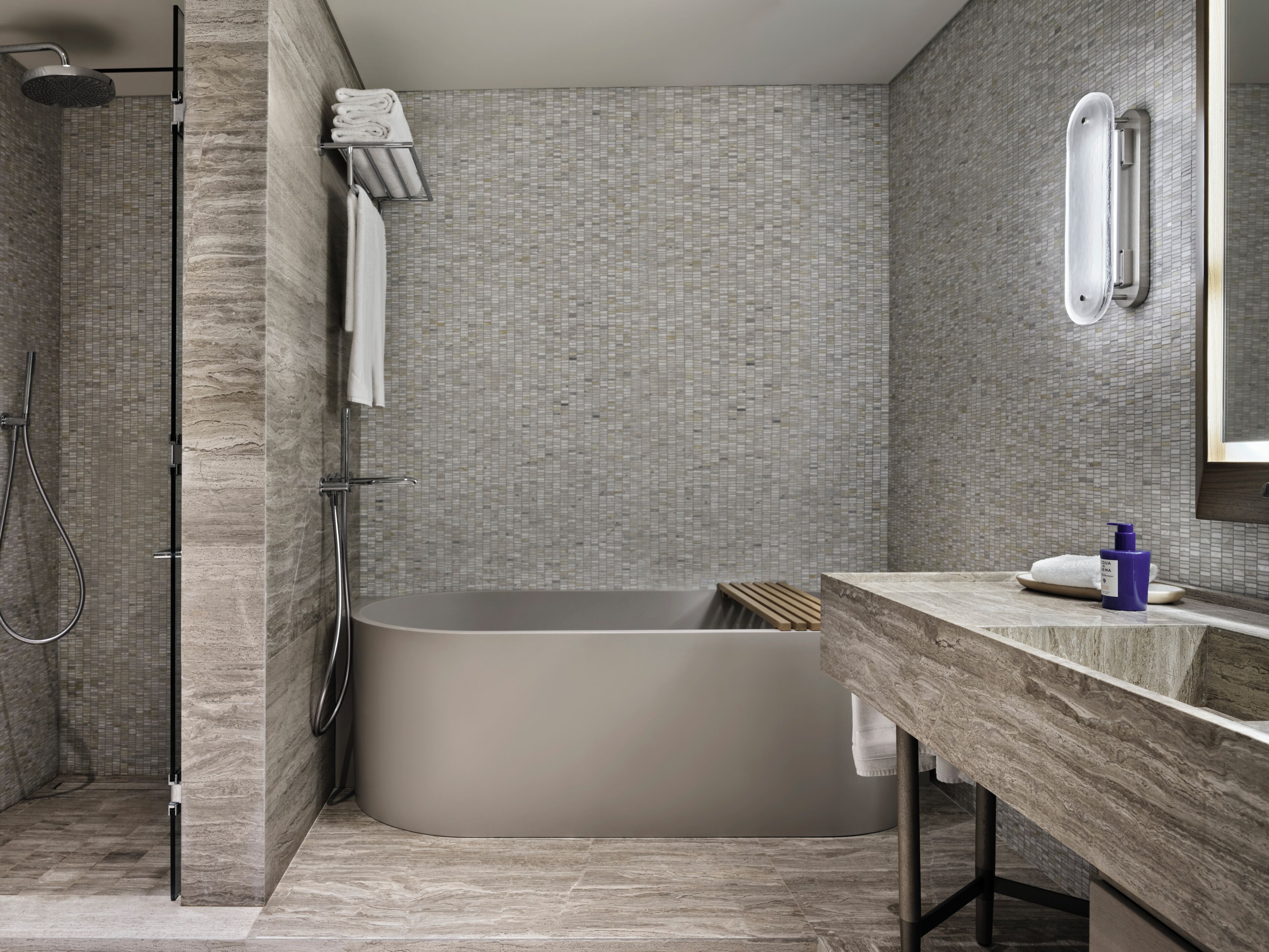 A modern bathroom with a freestanding bathtub, a shower area, and a vanity with a mirror.