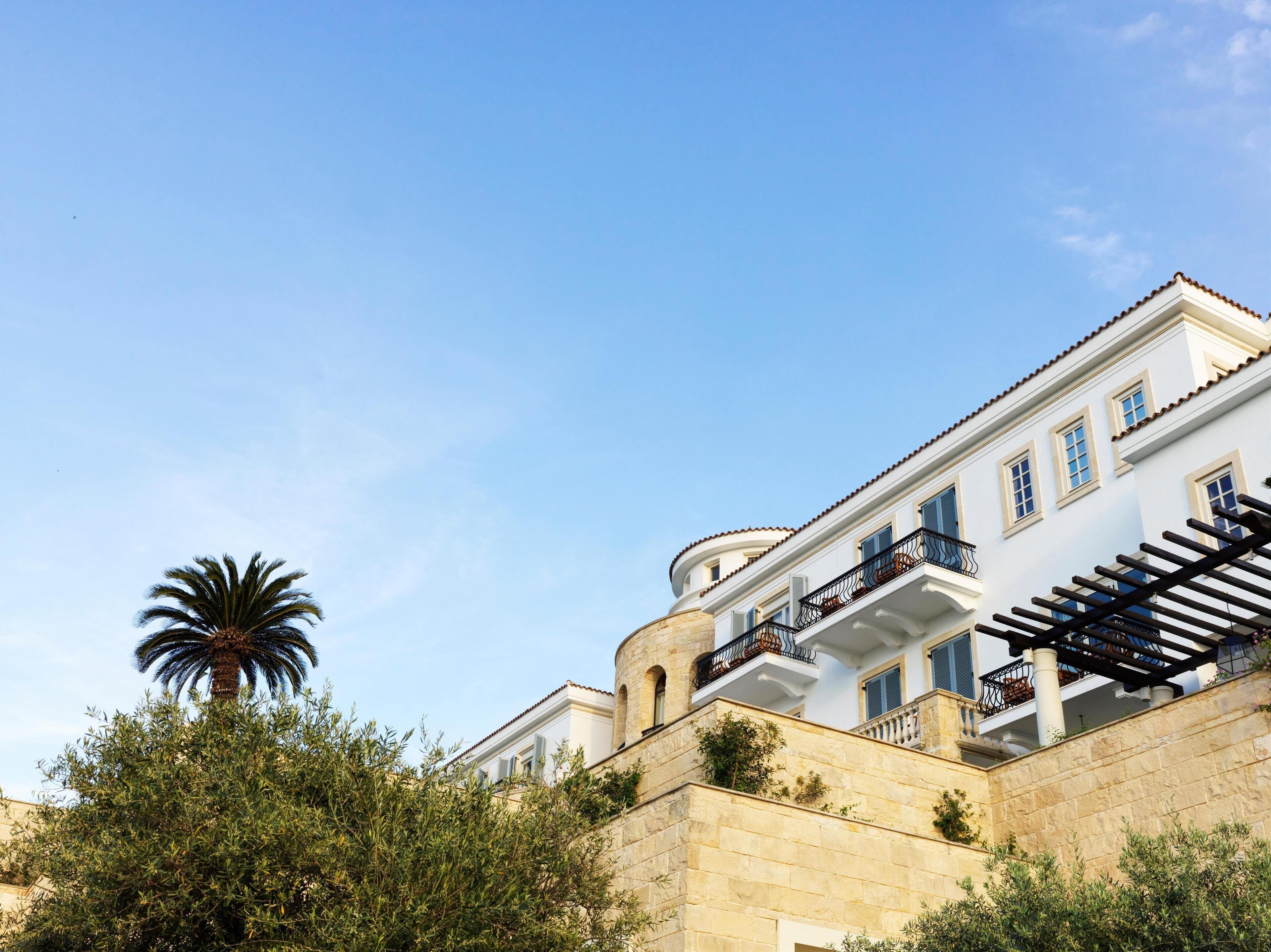 A multi-story building with balconies and a stone facade.