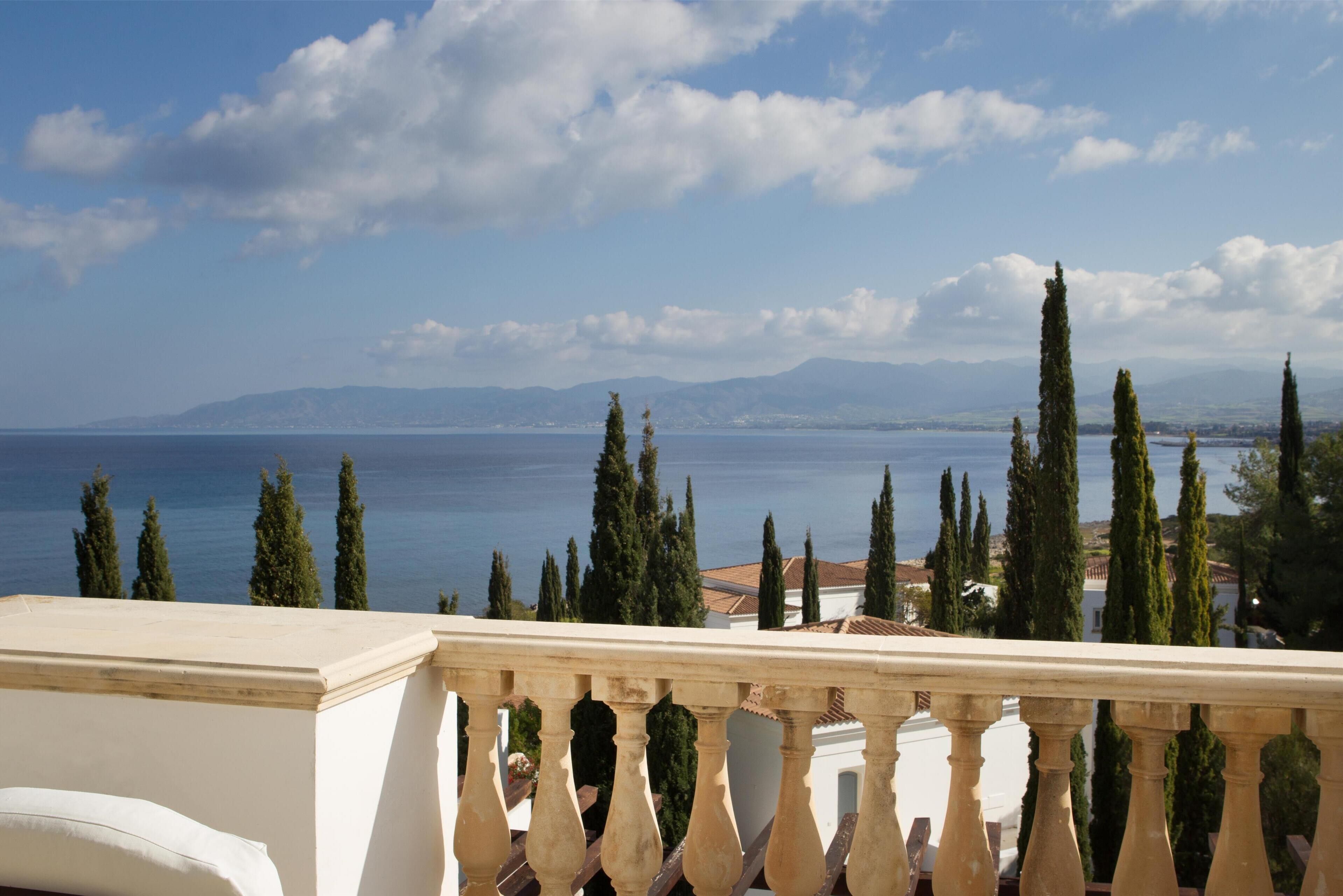 Ein Balkon mit Blick auf das Meer und ferne Berge.