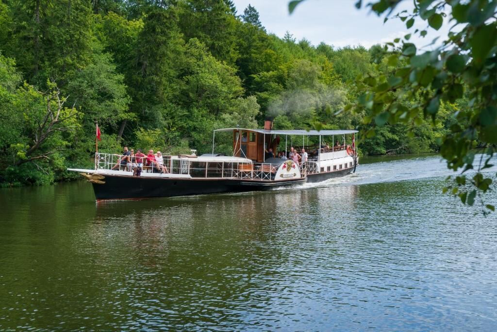 Ein Boot mit Passagieren, umgeben von üppiger Vegetation.