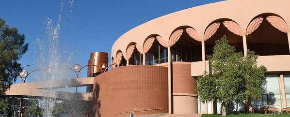 A building with a curved facade, a water feature, and a tree in the foreground. - Holiday Inn Express & Suites Tempe by IHG (Tempe)