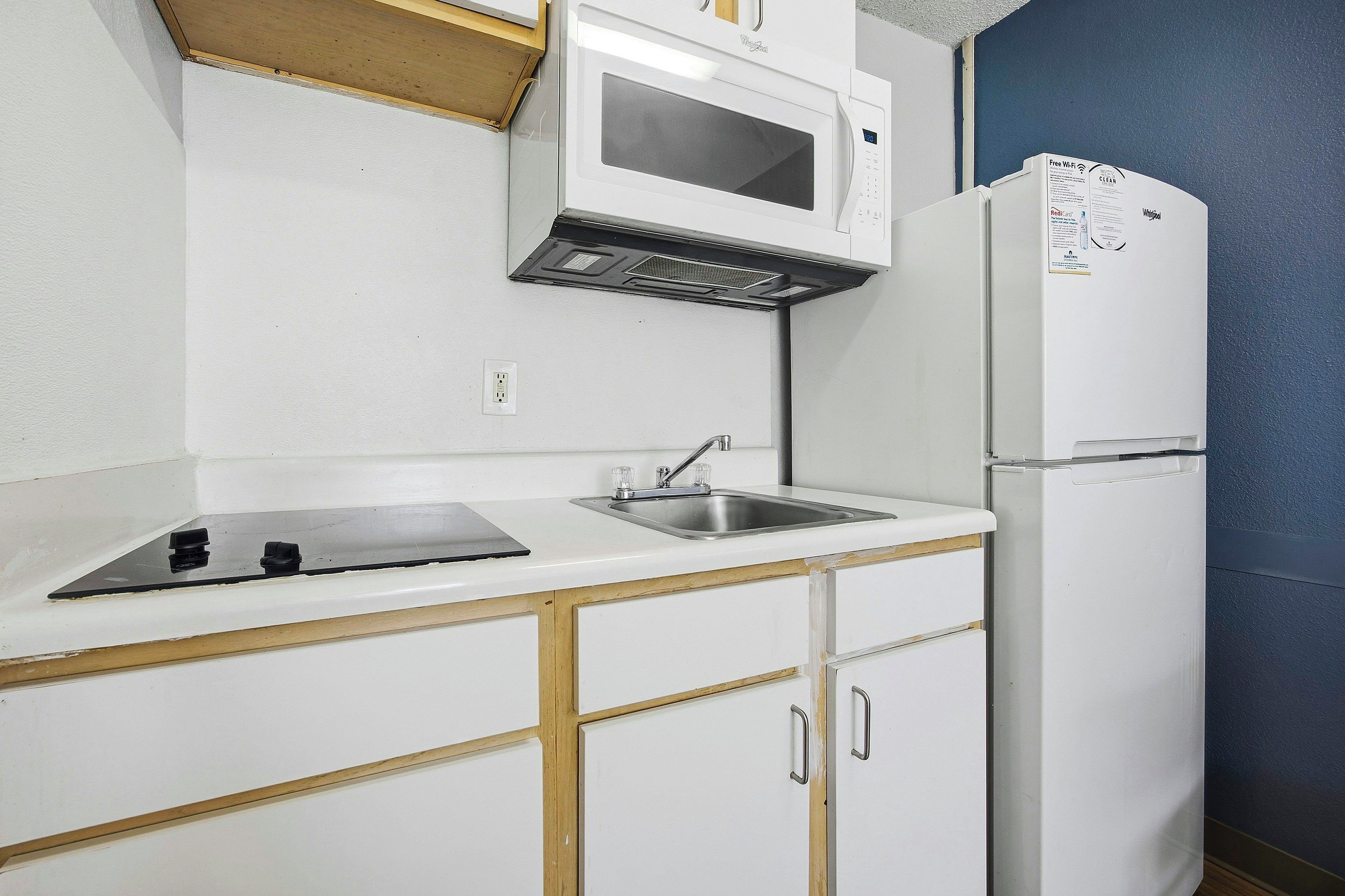 A kitchen with a microwave, sink, and refrigerator.