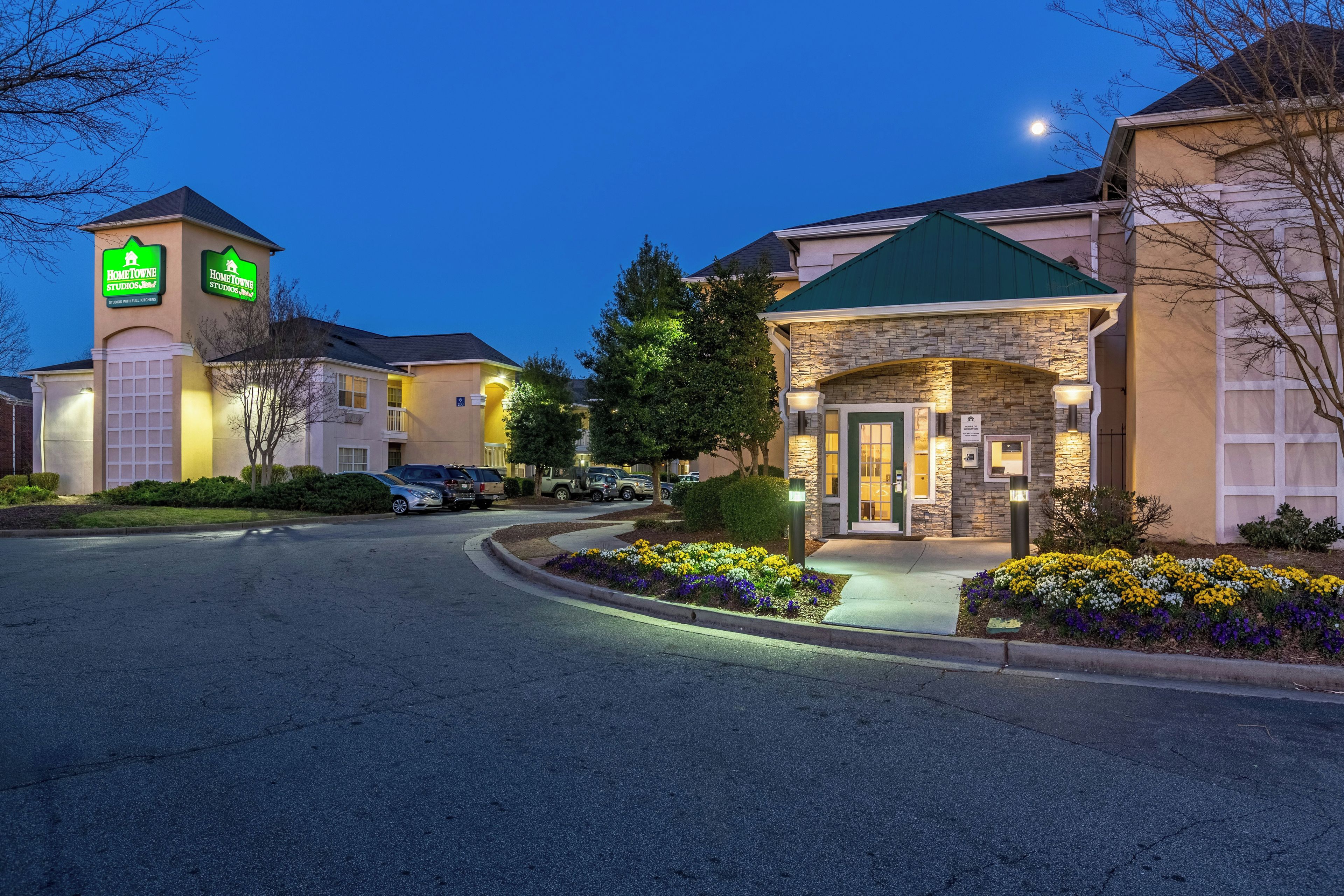 Un hotel con facciata in pietra, tetto verde e insegna che indica Hampton Inn.