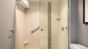 Un baño moderno con cabina de ducha de vidrio, inodoro y perchero para toallas.