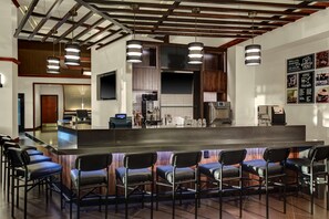 A modern bar area with a long counter, multiple bar stools, and overhead lighting. - Hyatt Place Pittsburgh Airport/Robinson Mall (Pittsburgh)