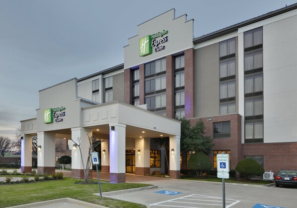 Un edificio de Holiday Inn Express con fachada de ladrillo, ventanas amplias y una zona de acceso cubierta.
