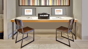 A modern office space with two desks, chairs, a large abstract painting, and two monitors displaying the IHG Rewards Club logo. - Holiday Inn Express & Suites Irving Conv Ctr - Las Colinas by IHG (Irving)