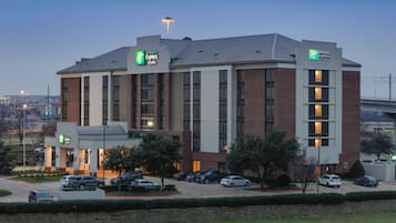 Um hotel Holiday Inn Express & Suites com design moderno, apresentando fachada de tijolos e grandes janelas.