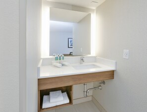 Een moderne badkamer met een wit wastafelmeubel, een spiegel en een handdoekhouder.